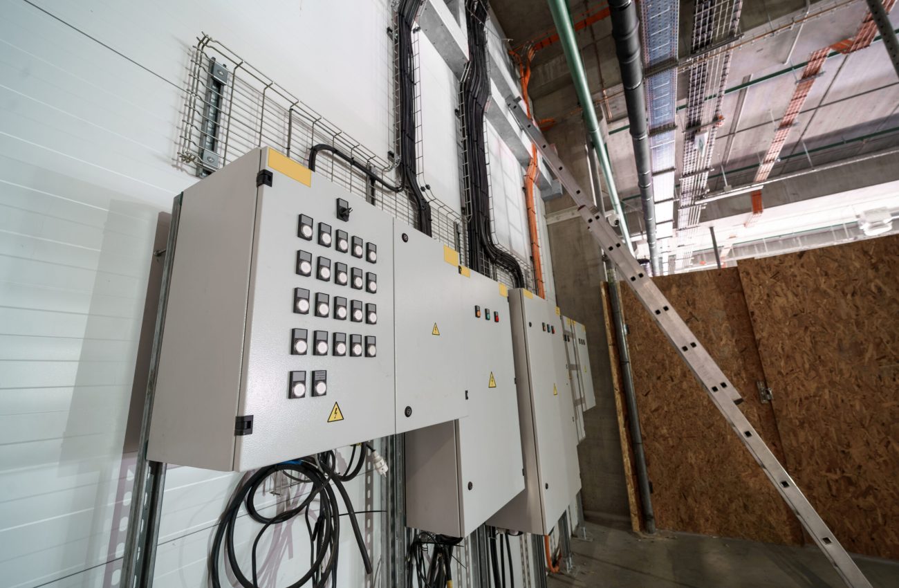 Electrical control panels with wiring and switches, located in a modern industrial facility. Used for power management and control